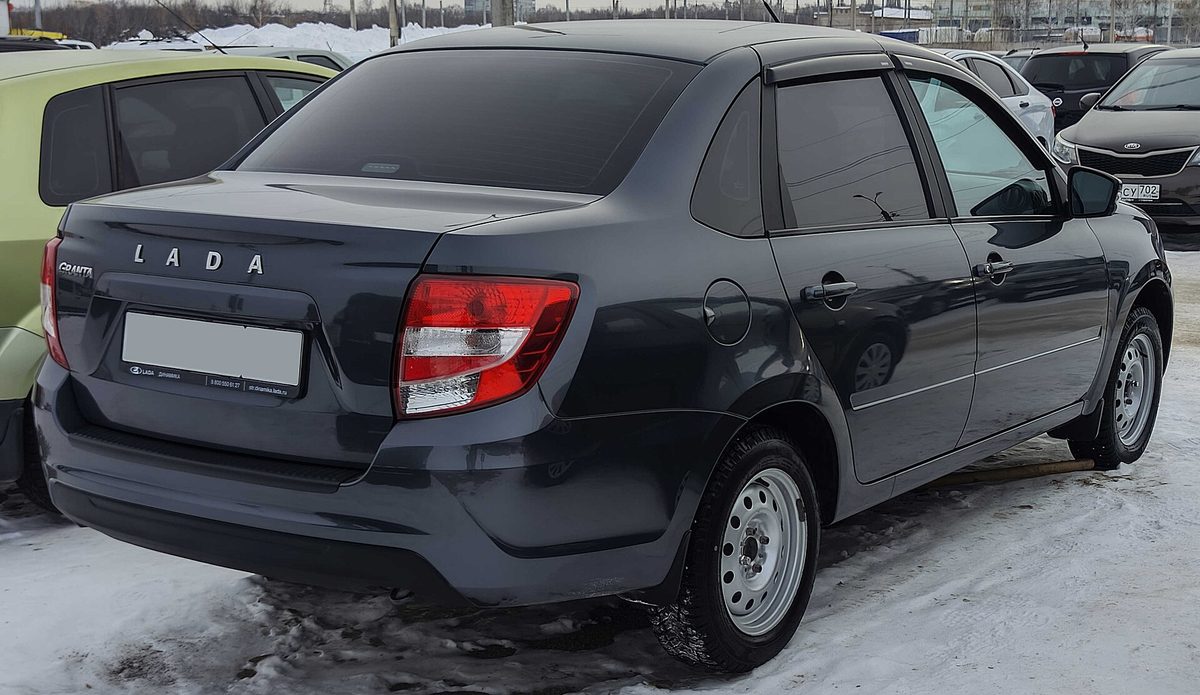 Серая Lada Granta, вид сзади на парковке зимой — одна из самых часто страхуемых по ОСАГО моделей