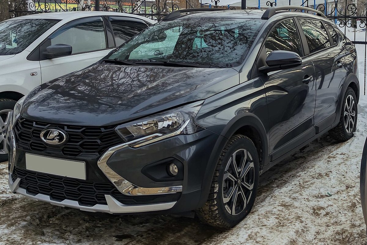 Серый универсал Lada Iskra SW Cross на заснеженной парковке, вид спереди сбоку