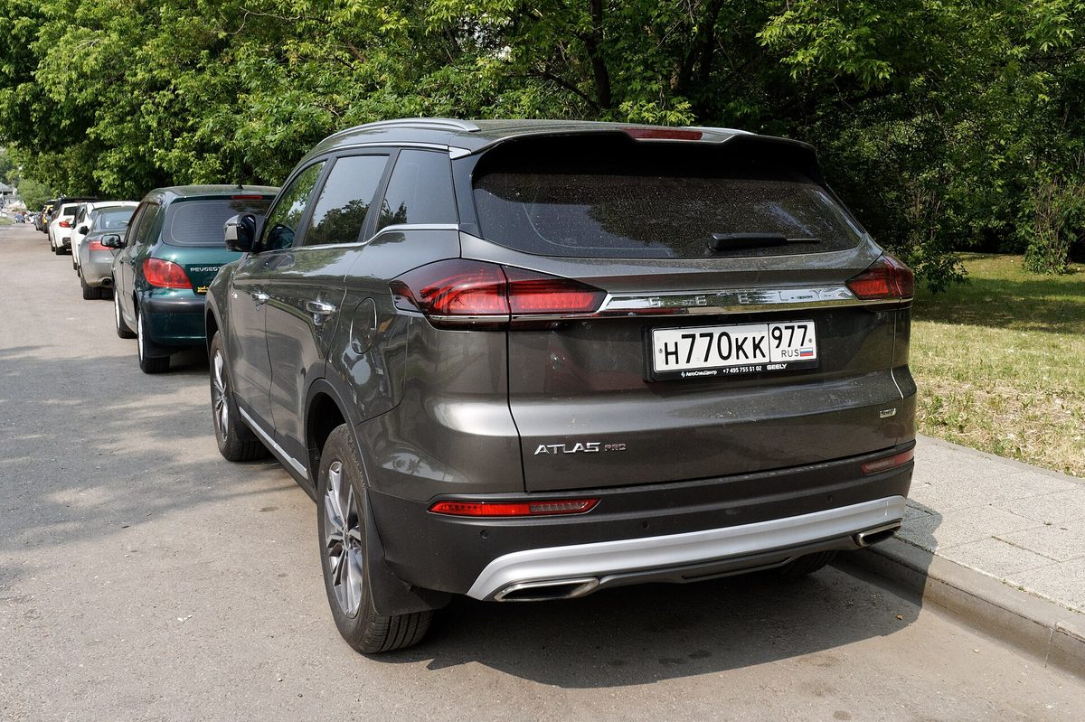 Geely Atlas Pro, серый, вид сзади три четверти, сфотографирован в Москве