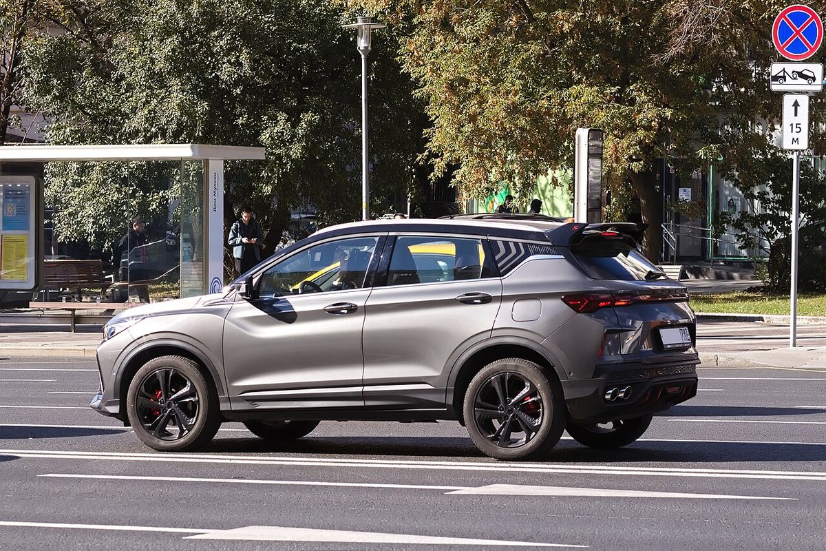 Серый Geely Coolray рестайлинга на московской улице, вид сзади сбоку