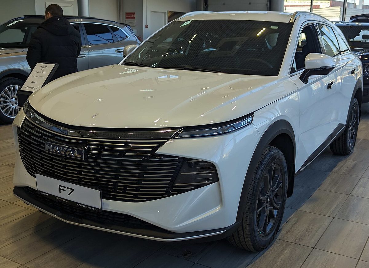 Белый Haval F7 второго поколения в полноприводной версии, вид спереди в дилерском салоне
