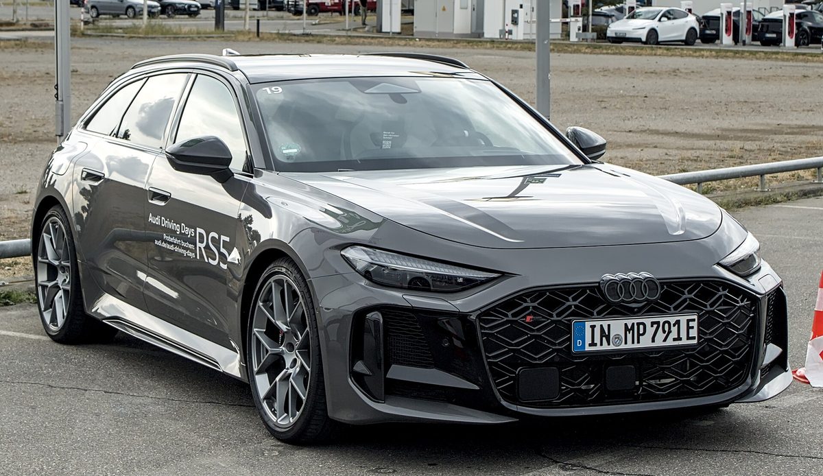 Серый Audi RS5 Avant (B10) нового поколения с надписью RS5 на двери, вид спереди-сбоку