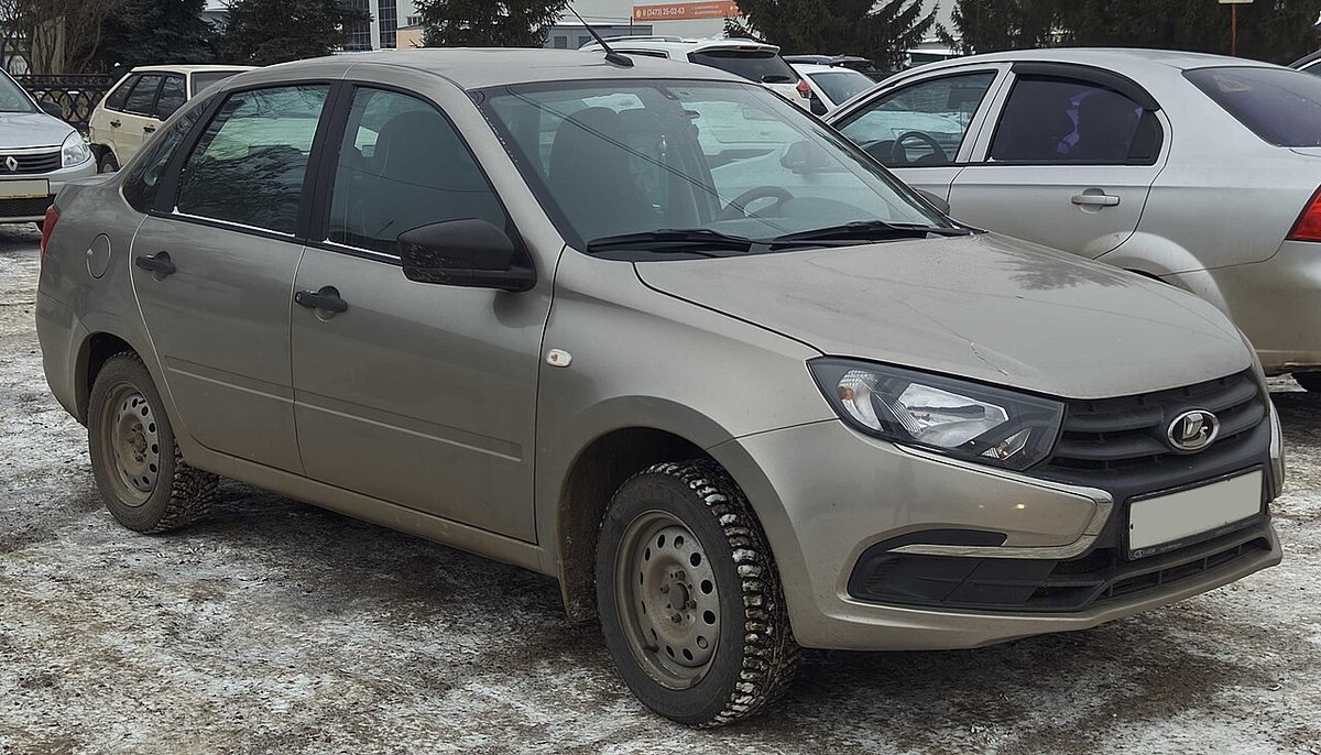 Седан Lada Granta после рестайлинга 2018 года бежевого цвета на парковке, вид спереди сбоку