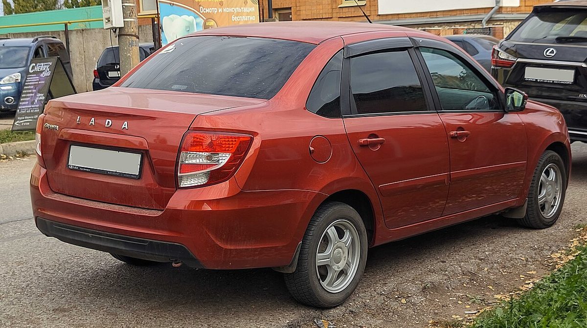 Красный седан Lada Granta после рестайлинга 2018 года, вид сзади сбоку