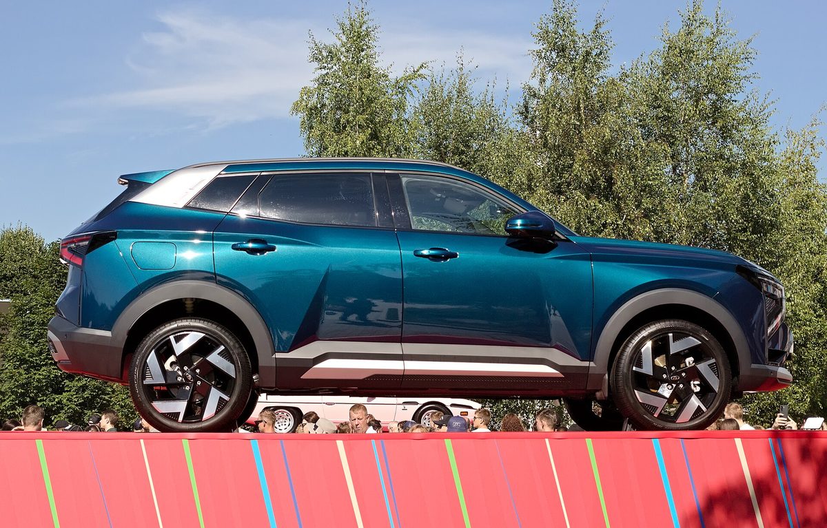 Lada Azimut 2027 модельного года сбоку: сине-зелёный кузов, серые накладки на арках и двухцветные диски